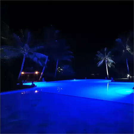 Color-changing pool light fixture creating a vibrant underwater display.