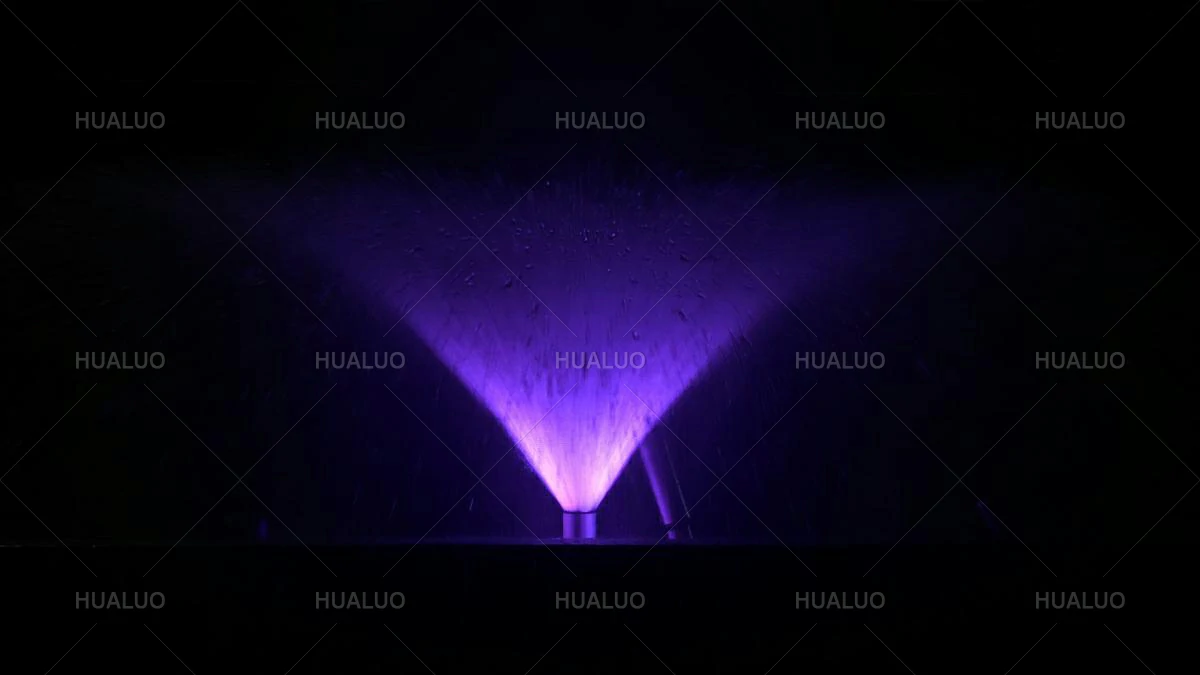 an omnidirectional fountain nozzle in the open position, with lights illuminating its structure.